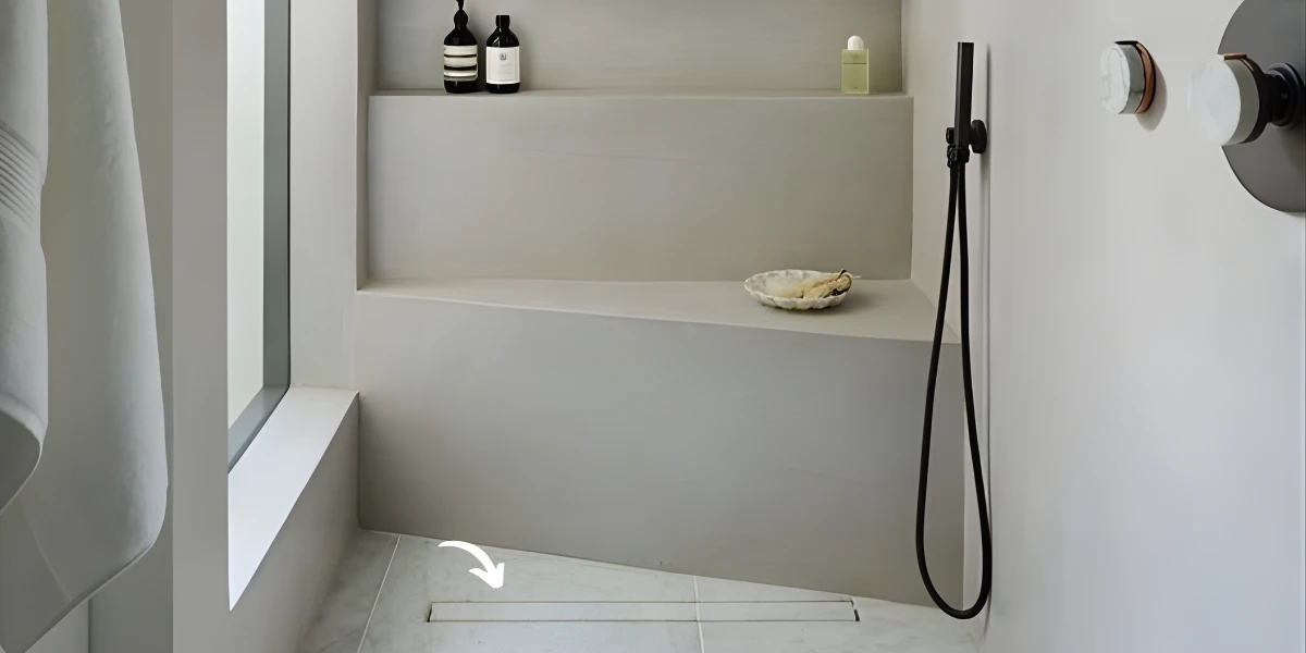 A minimalist walk-in shower with a sleek linear drain integrated into the tile floor, showcasing high-quality solutions from a professional floor drains manufacturer.