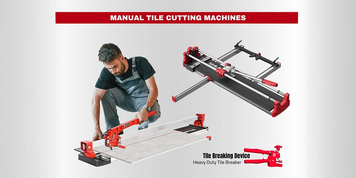 Two construction workers in hard hats operating a red manual tile cutting machine on a wooden workbench inside a building under renovation.
