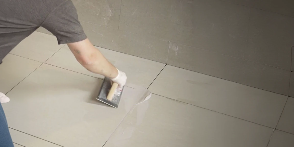 Tile Grout Manufacturer in UAE – Premium Floor Tile Grouting Solutions Tile Grout Manufacturer in UAE applying premium grout to large floor tiles for a seamless finish