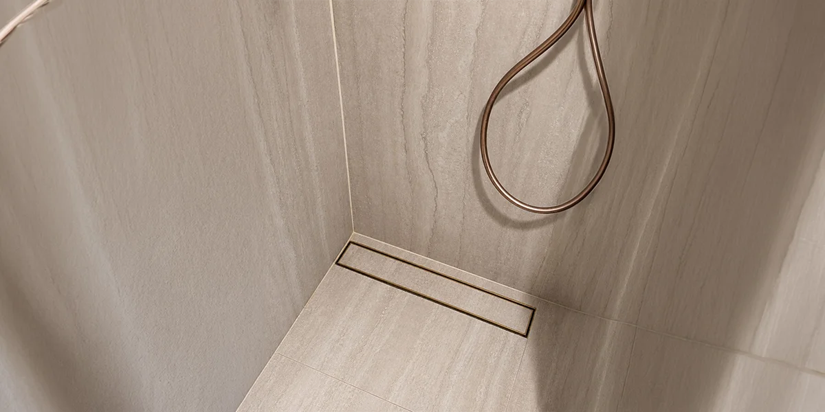 Industrial Floor Drains UAE featuring a linear drain installed along the edge of a modern tiled shower.