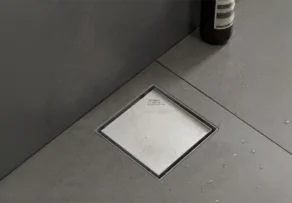 Industrial Floor Drains UAE: How Do Different Drain Types Meet Industrial Drainage Requirements? 1 Industrial Floor Drains UAE featuring a square stainless steel drain installed in a tiled floor.