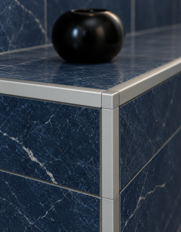 Aluminum tile edge profile protecting the corner of a blue marble-effect tiled surface.