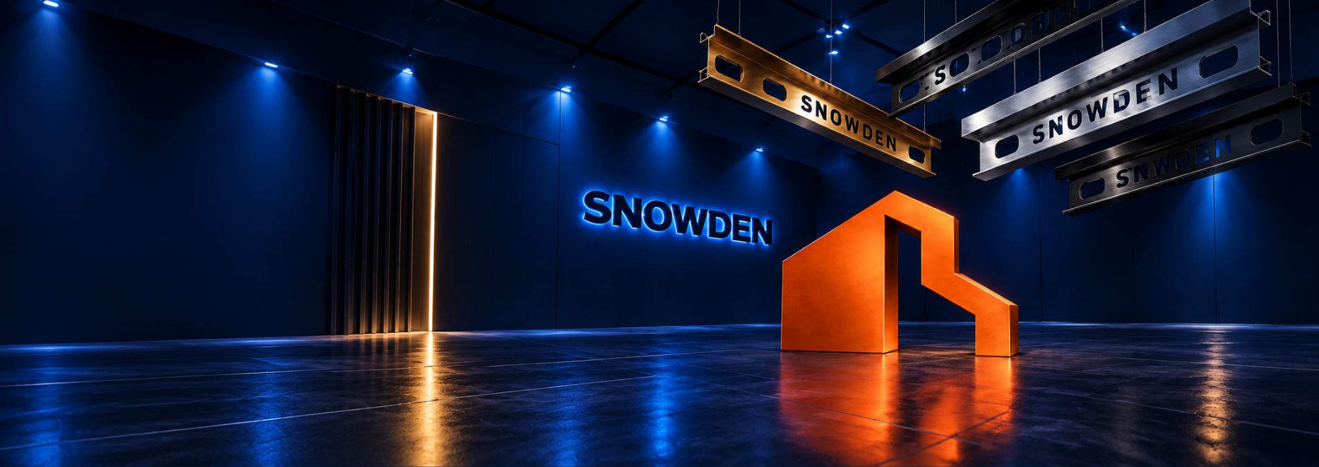 Modern showroom with deep blue walls, illuminated Snowden branding, an orange geometric logo sculpture, and suspended metal profile samples.